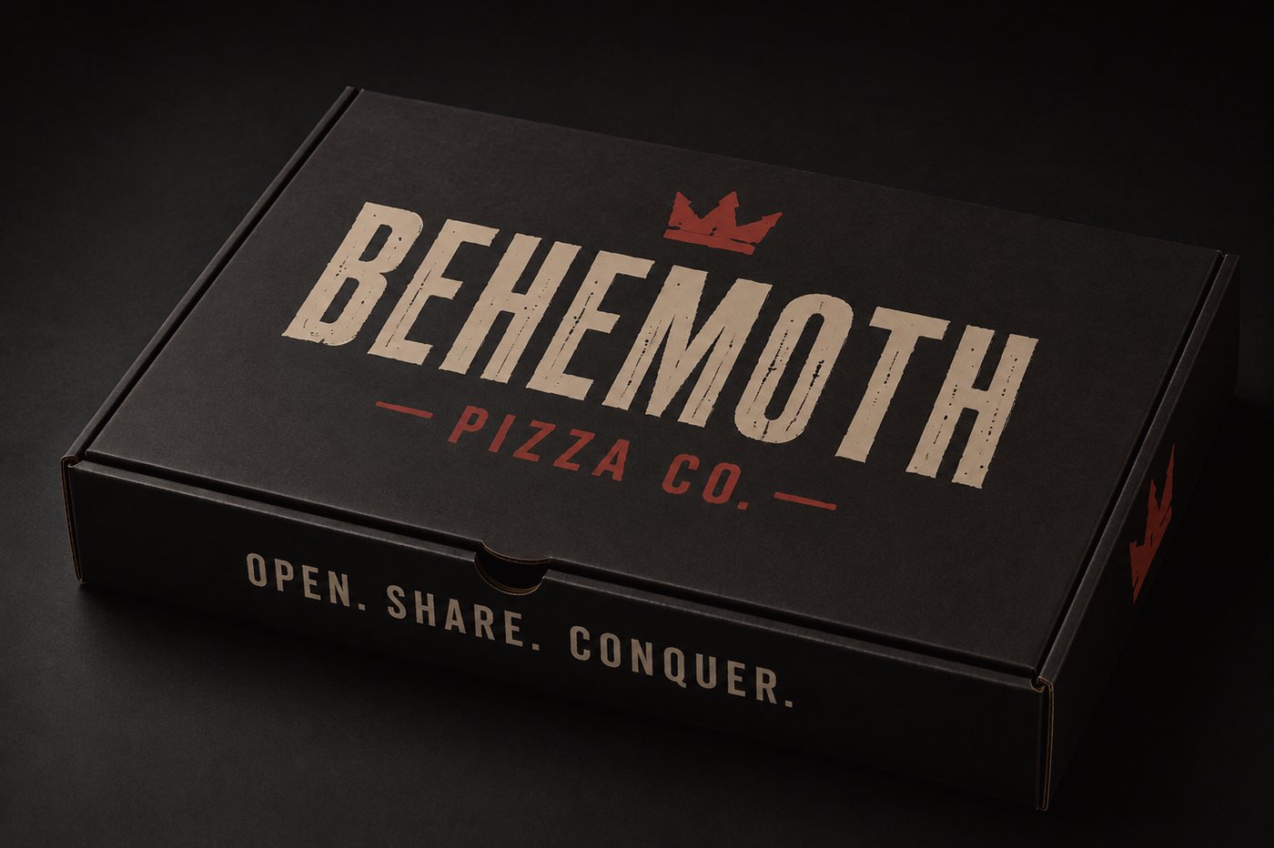 A black Behemoth Pizza Co. pizza box printed with the crown wordmark and the words Open. Share. Conquer.